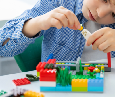 Junge baut mit Legosteinen