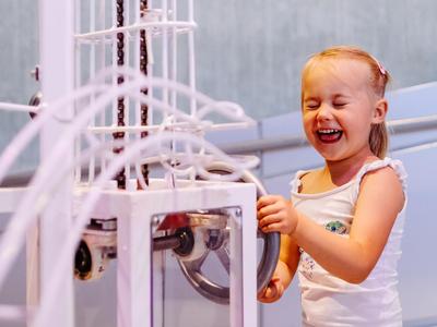 a little girl has a lot of fun on a marble run and laughs