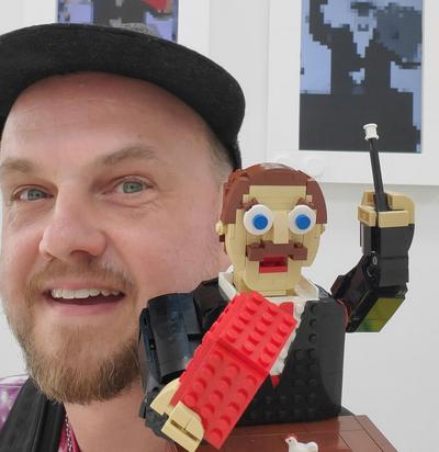 Mann mit einer Legofigur auf der Schulter