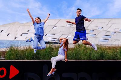 Kinder springen vor dem Museum in die Luft